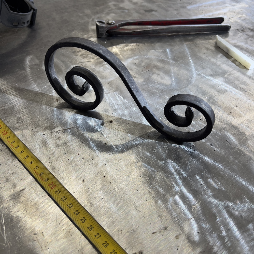 Volute en S inégale finition coupe pointue. Hauteur 210mm largeur 100mm en fer plat de 12x6mm. Fixation par soudure. Permet de décorer votre fabrication en fer forgé, portail, clôture, pergola, mais également permet de renforcer la sécurité, en diminuant le vide entre barreau, ou d'augmenter le soutien. Fourni brut, à peindre ou à vernir pour protéger contre la corrosion.