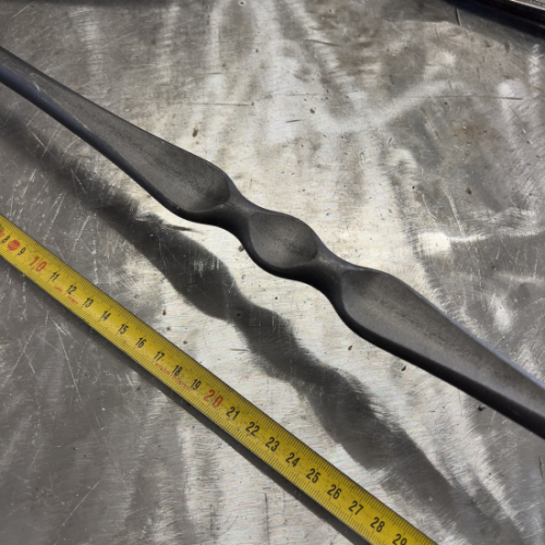 Barreau estampé motif aplati au centre avec équerre de rampe intégré, en fer forgé. Hauteur 1100mm rond lisse plein de diamètre 14mm, hauteur du motif 290mm, déport du barreau 65mm. Fixation par soudure. Fourni brut, à peindre ou à vernir pour protéger de la corrosion. Au delà de son rôle sécuritaire, il peut être un élément décoratif dans plusieurs réalisations en fer forgé tel que du mobiliers, divers objets décoratifs, des grilles de défense, des rampes d'escaliers, des portails, des kiosques, des gardes corps.