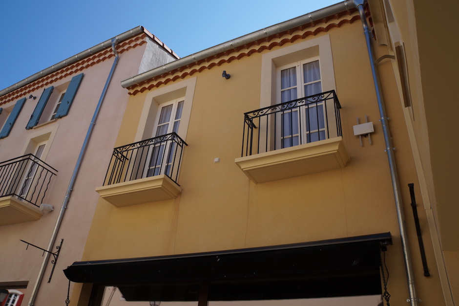 Garde-corps et porte enseigne en fer forgé visible au village des marques de miramas